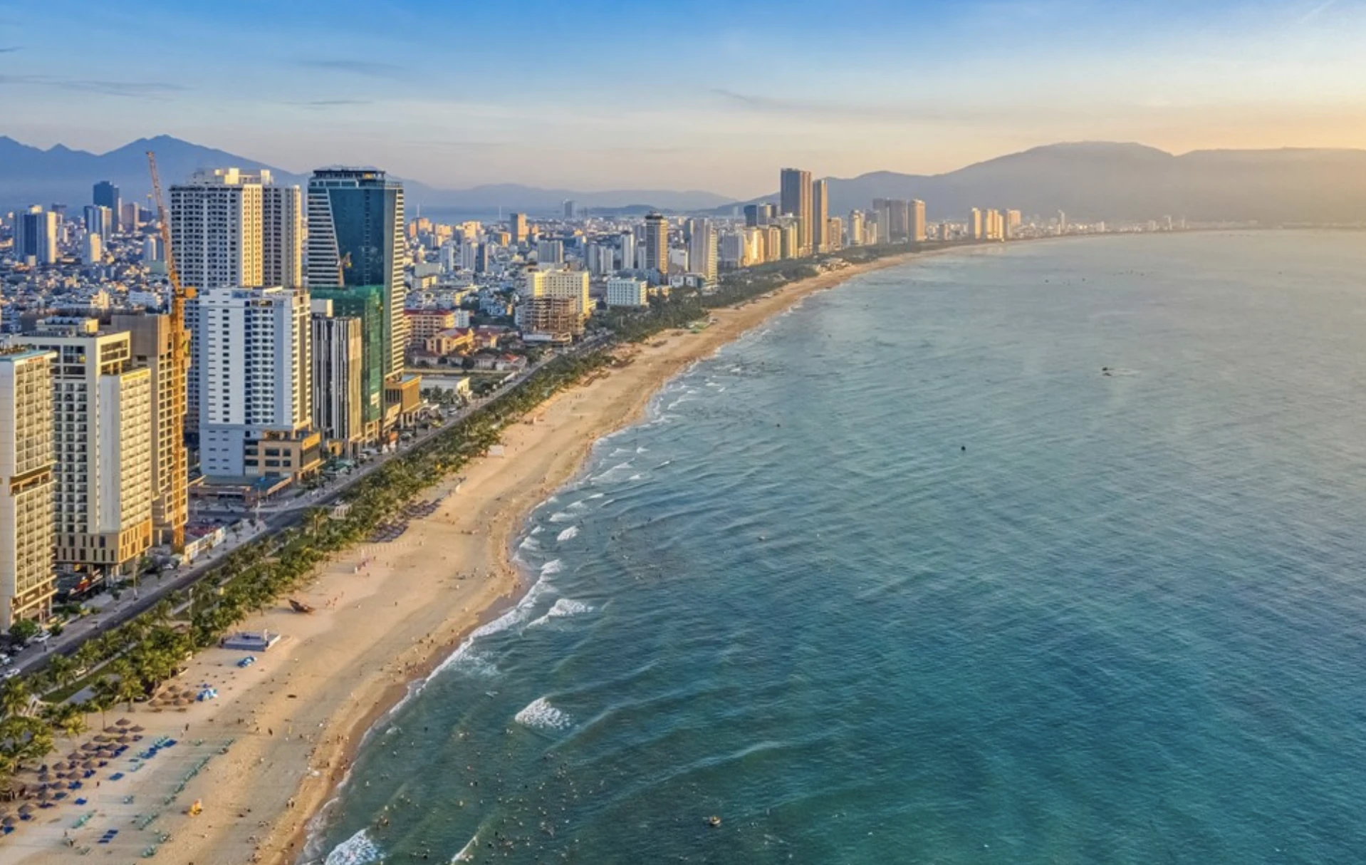 Da Nang’s beachfront, skyline and mountains in warm evening light
